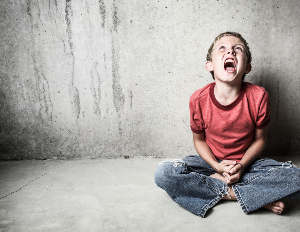Child sitting crossed leg on the floor looking up at the sky screaming