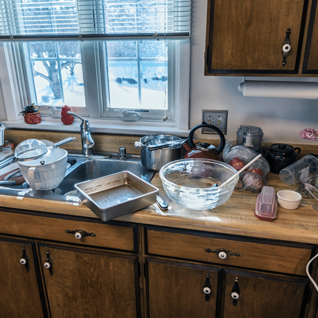 Messy kitchen with bowls and dishes on the counter and in the sink, 